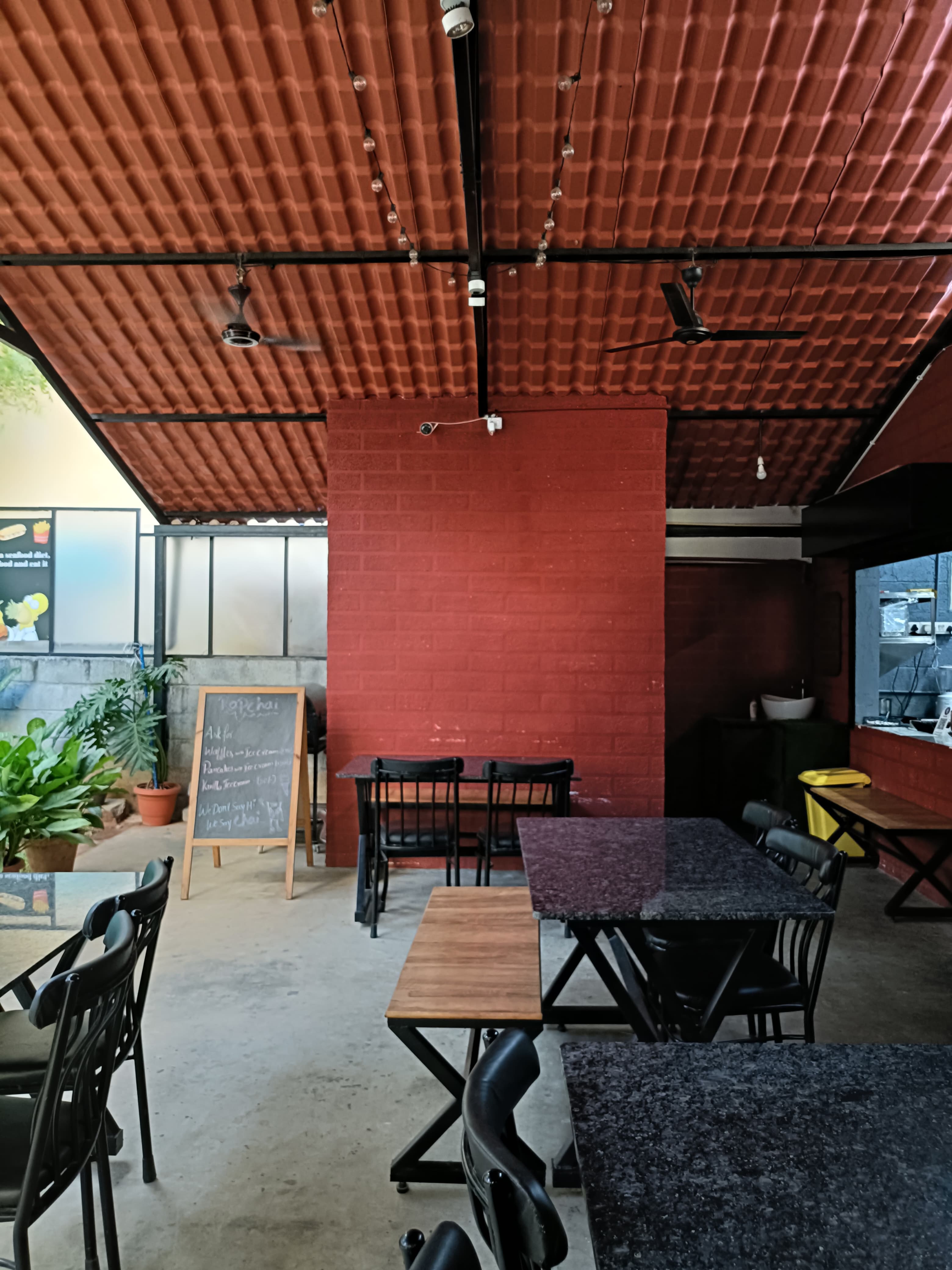 Rapchai indoor seating with red brick wall and string lights